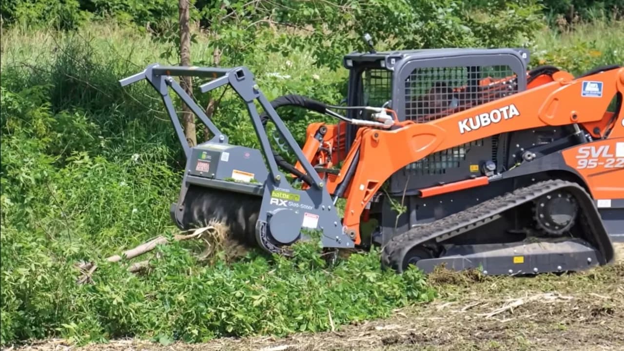 Compact track loader with a forestry mulching head clearing brush