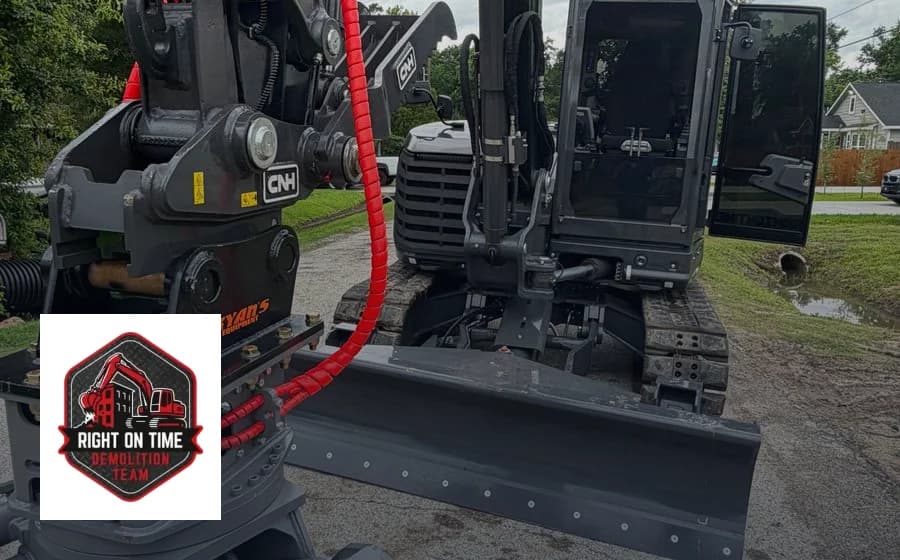 A demolition company's excavator fitted with a demolition grapple, with the company logo
